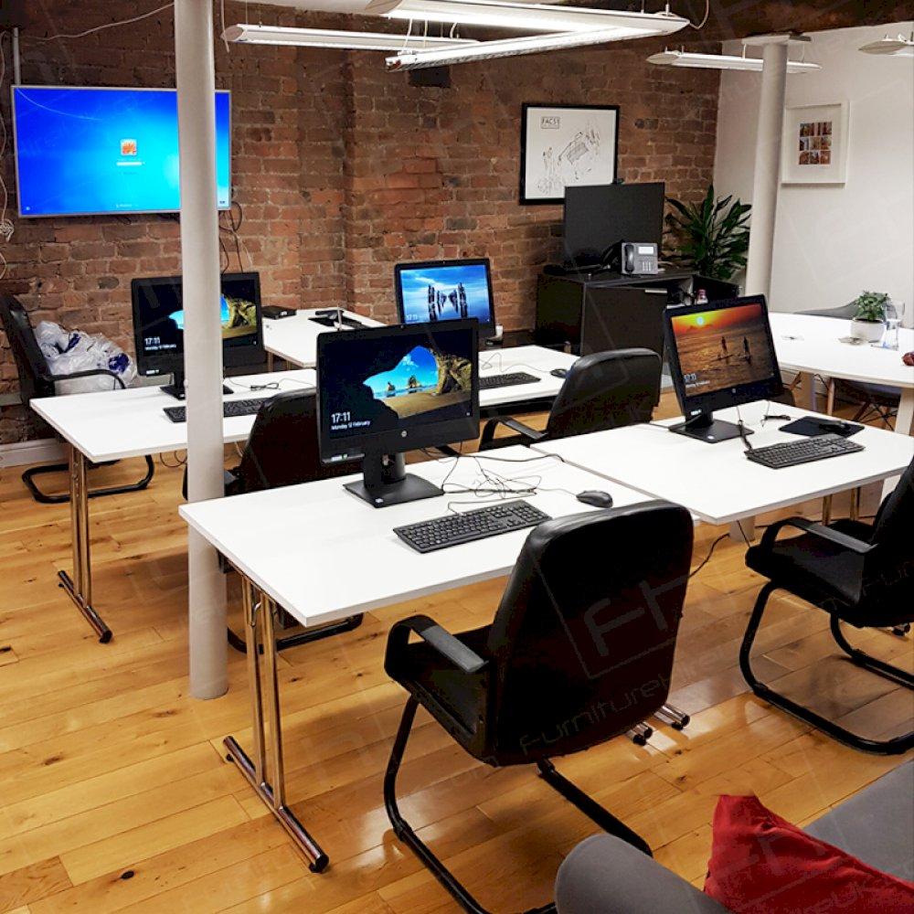 Black cantilever chairs hired alongside white modular tables for a training event.