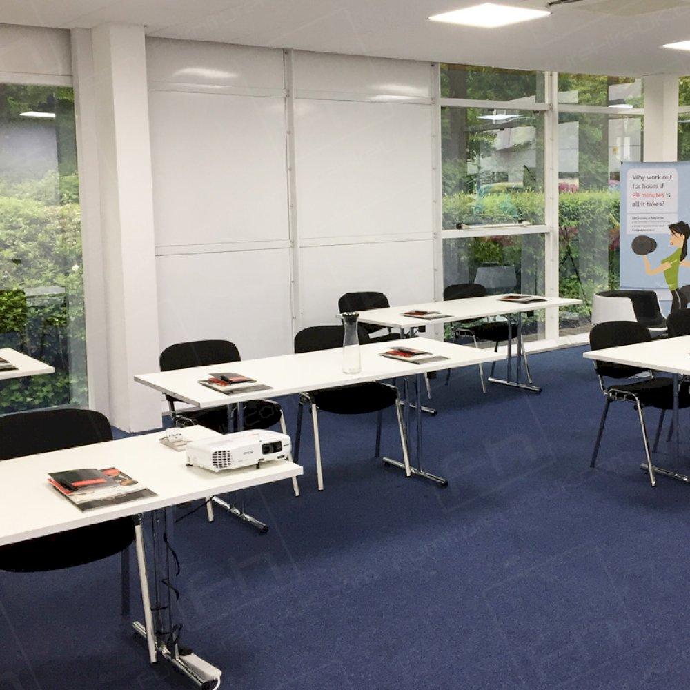 White modular tables with stacking chairs hired for a training room.